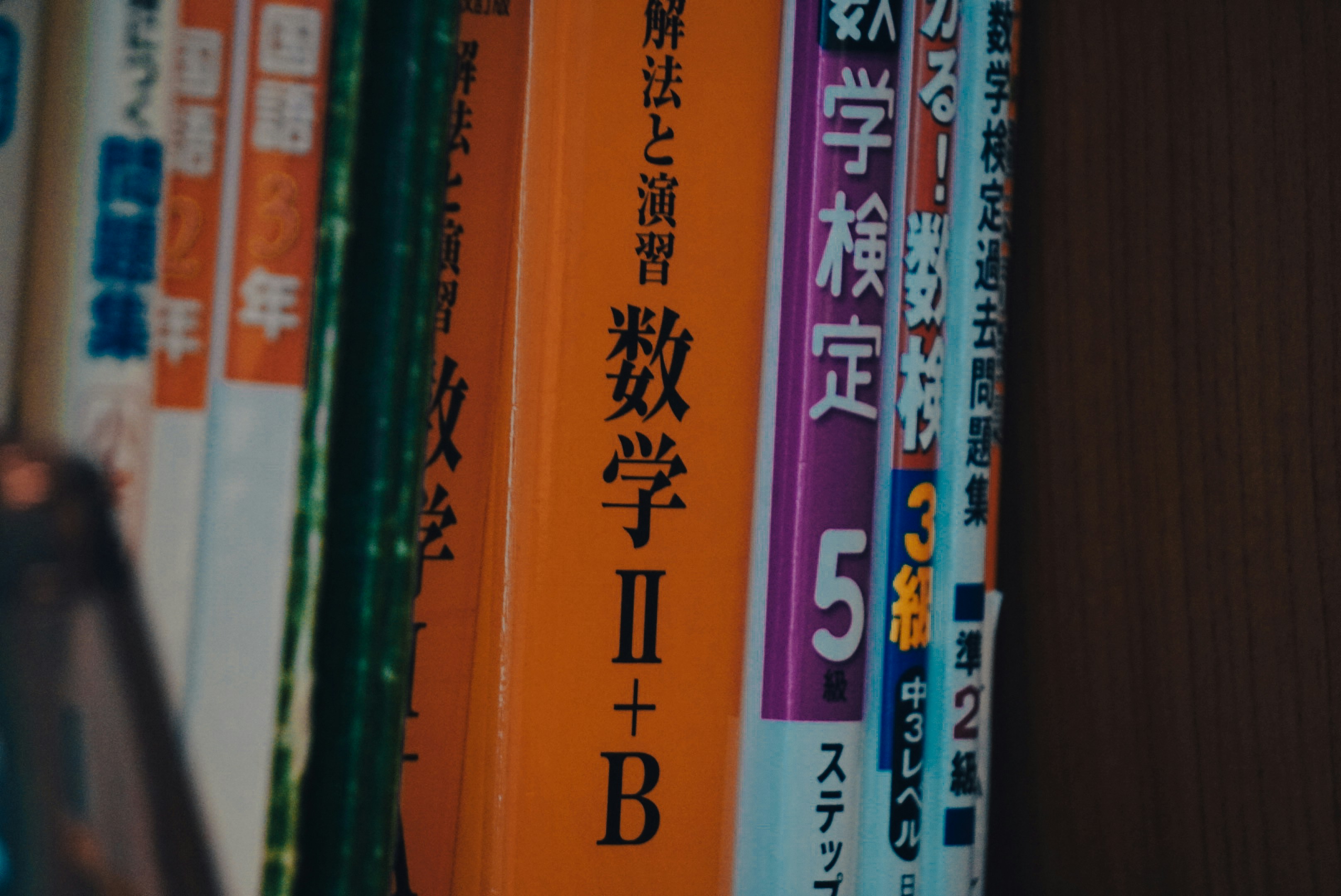 活字が抽象的に散りばめられた背景に、一冊の本が置かれている様子