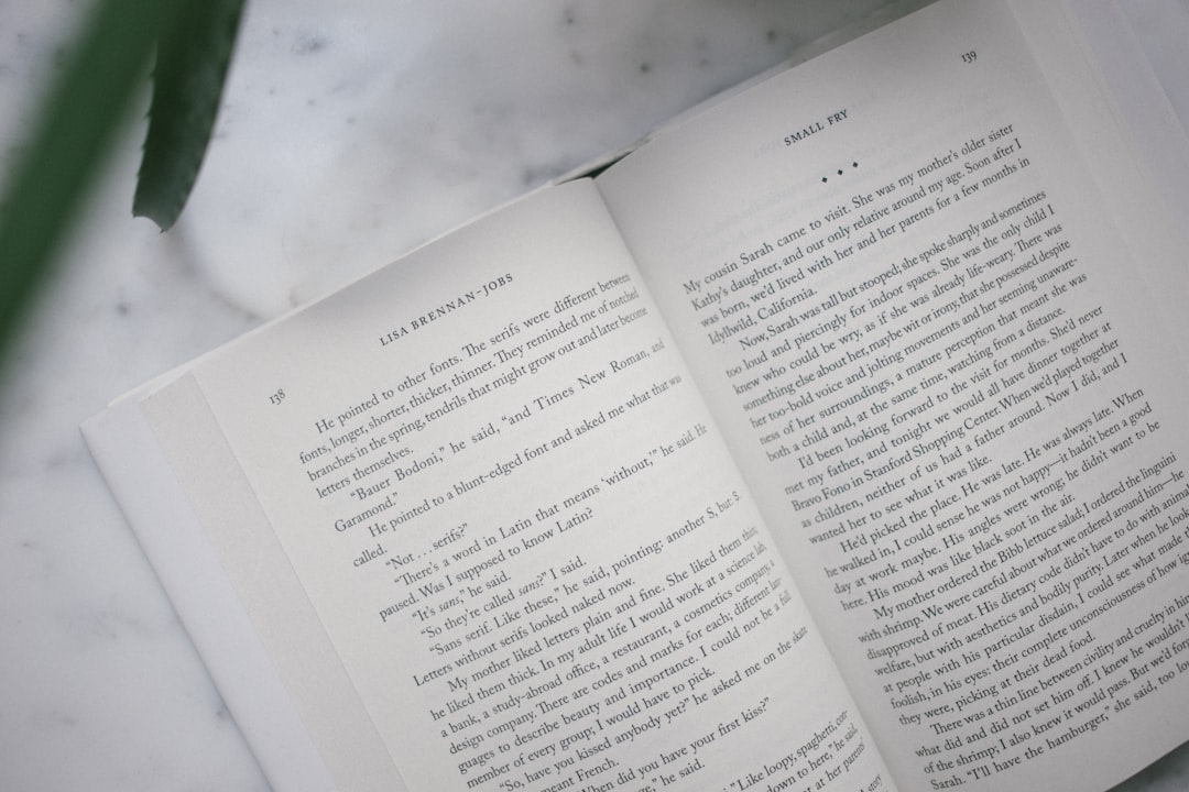 本を読みながら、ノートにメモを取っている手元のクローズアップ